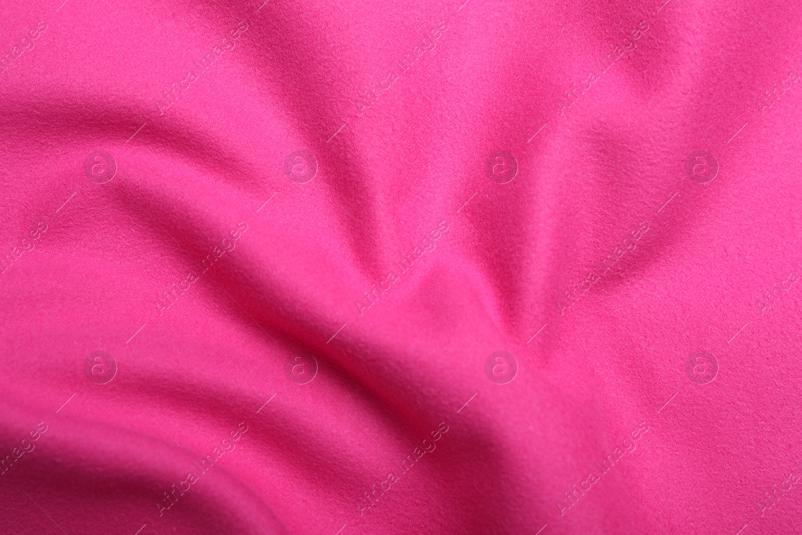 Photo of Crumpled pink microfiber cloth as background, closeup