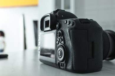 One professional photo camera on grey table, closeup