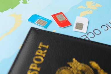 Photo of Passport and SIM cards on world map, closeup