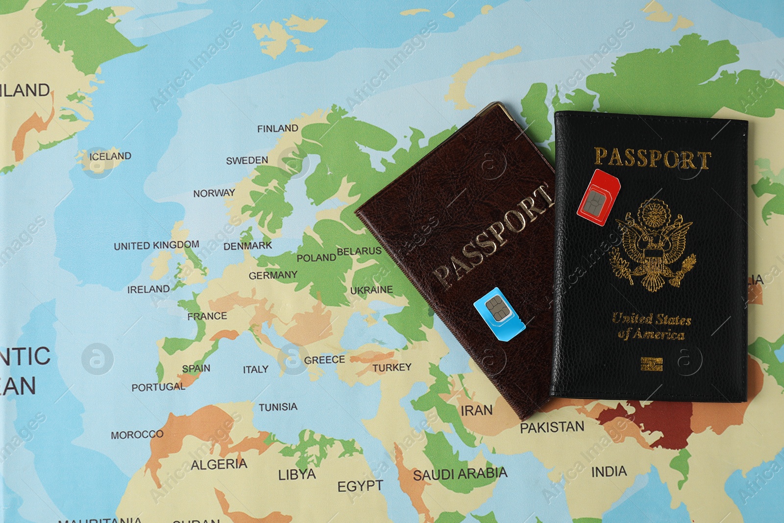 Photo of SIM cards and passports on world map, flat lay