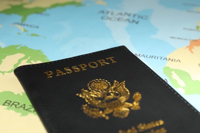 Passport in black cover on world map, closeup