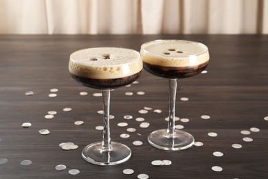 Fresh coffee cocktails in glasses and confetti on wooden table