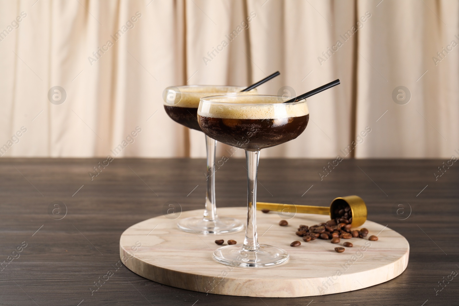 Photo of Fresh coffee cocktails in glasses and beans on wooden table