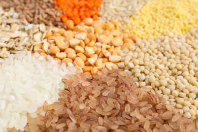 Photo of Different cereal grains as background, closeup view