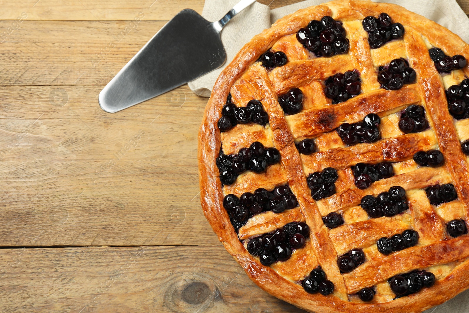 Photo of Tasty homemade pie with blueberries served on wooden table, flat lay. Space for text