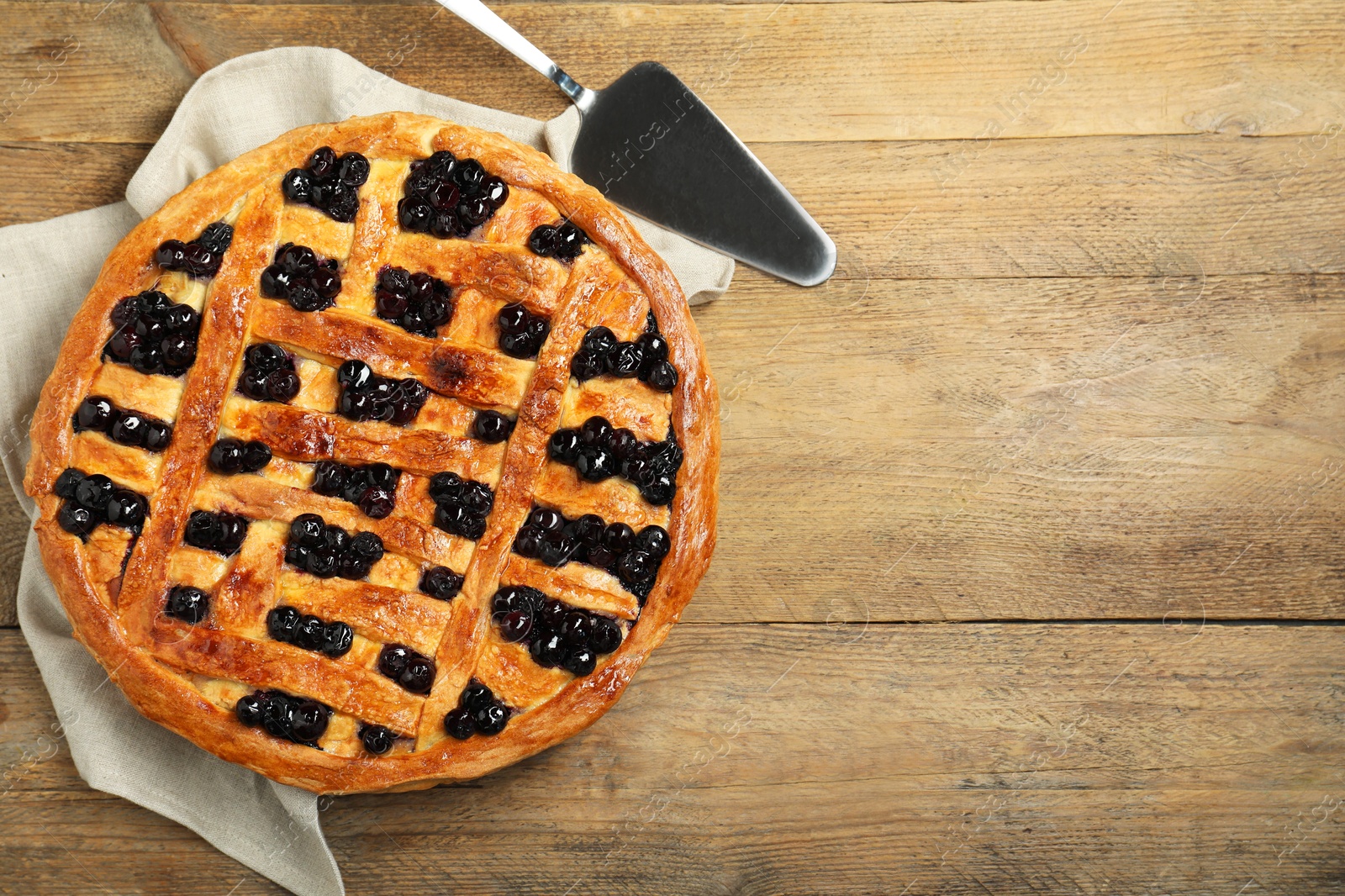 Photo of Tasty homemade pie with blueberries served on wooden table, flat lay. Space for text