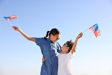 Photo of Brother and sister with flags of USA outdoors