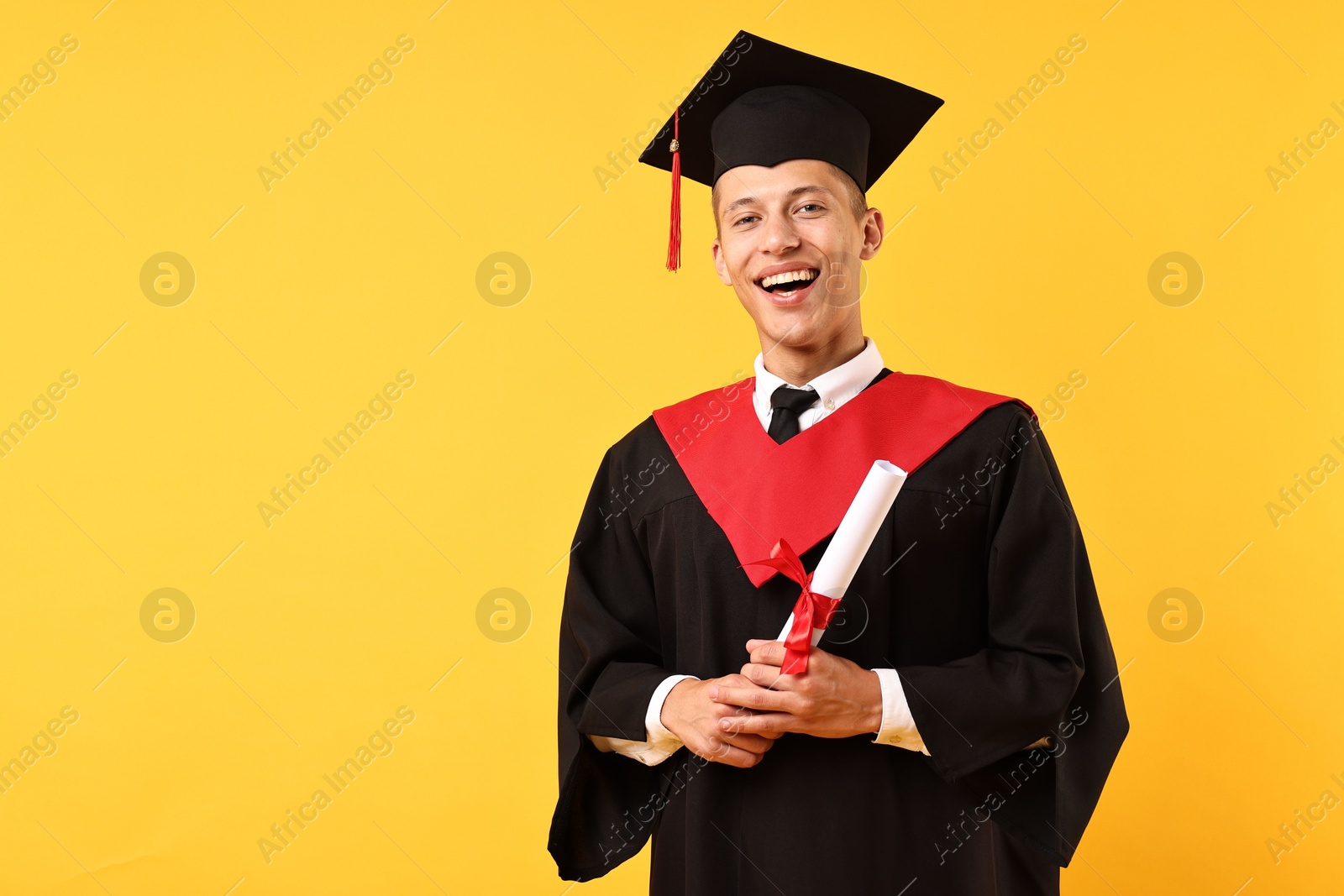 Photo of Happy student with diploma after graduation on orange background. Space for text