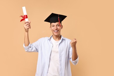 Photo of Happy student with diploma after graduation on beige background