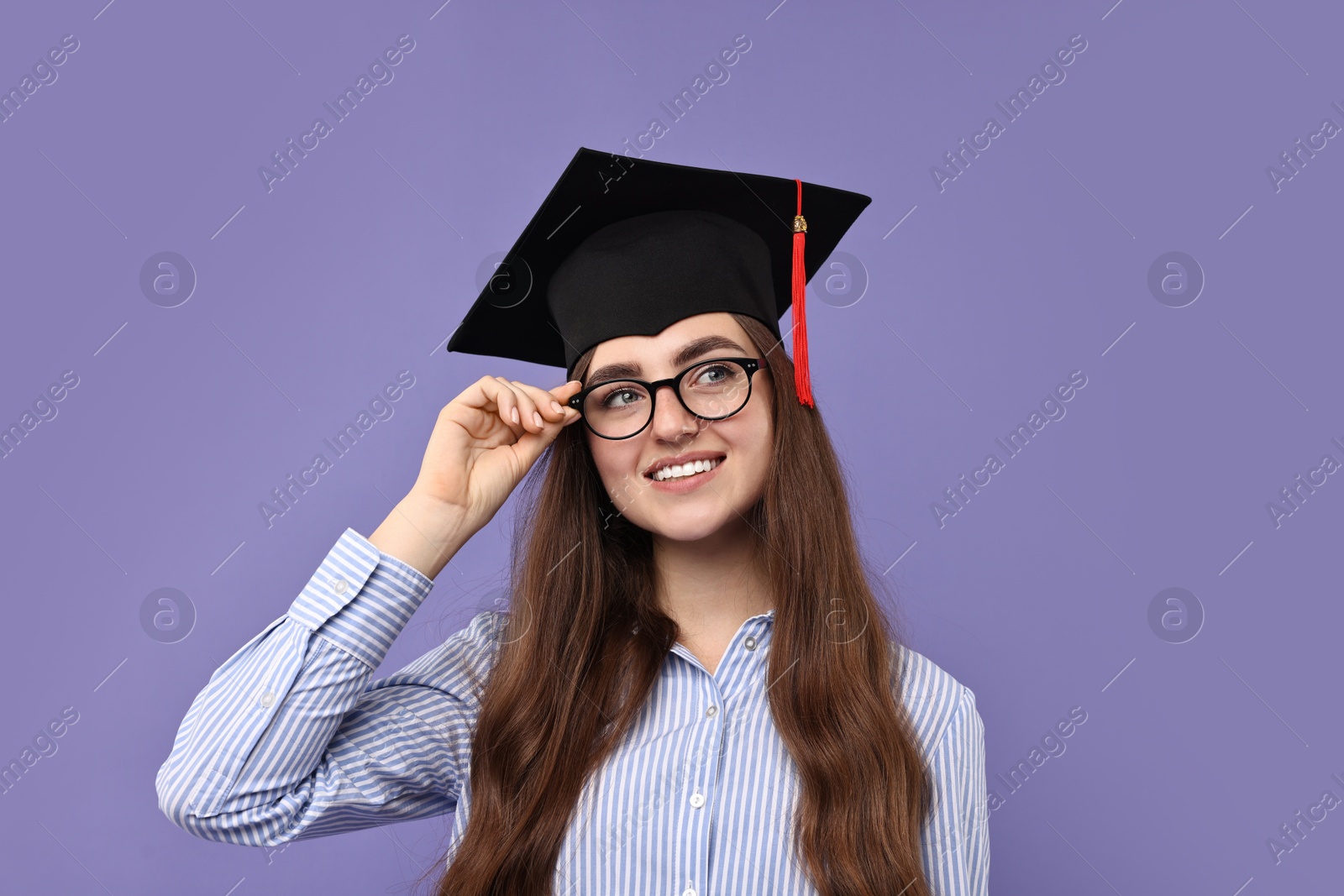 Photo of Happy student after graduation on violet background