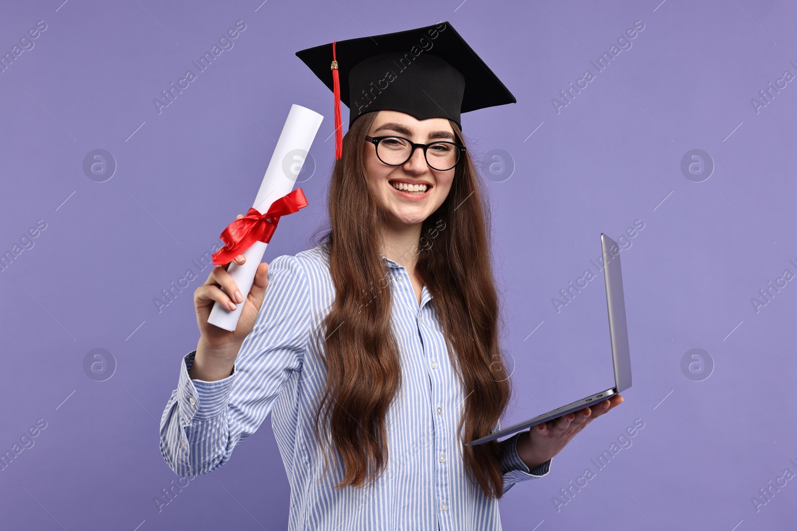 Photo of Happy student with laptop and diploma after graduation on violet background