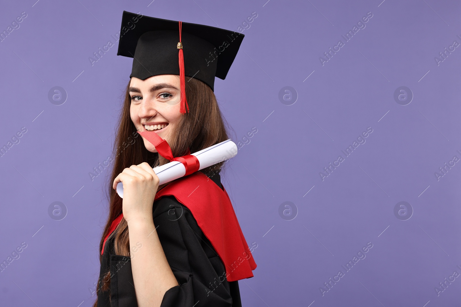 Photo of Happy student with diploma after graduation on violet background. Space for text