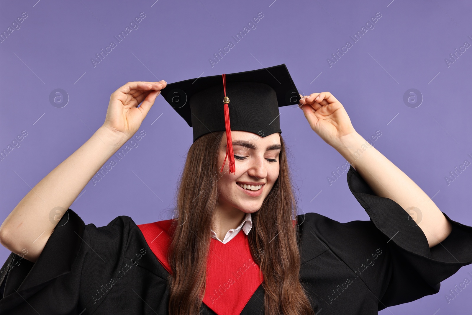 Photo of Happy student after graduation on violet background