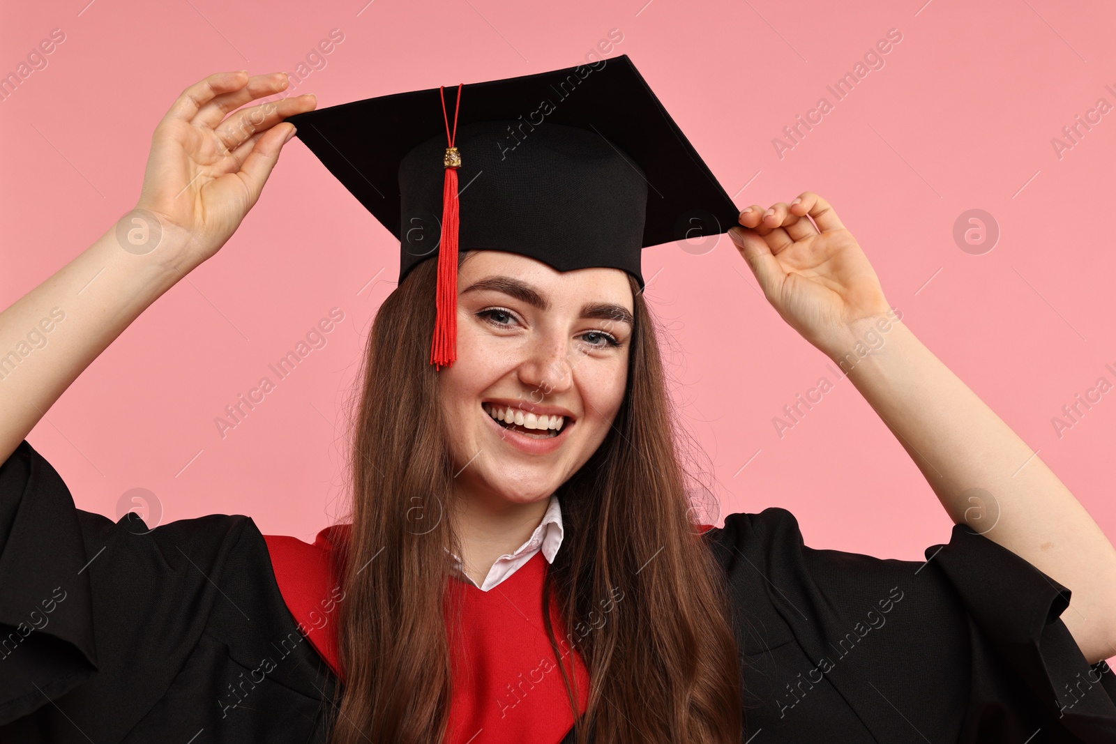 Photo of Happy student after graduation on pink background