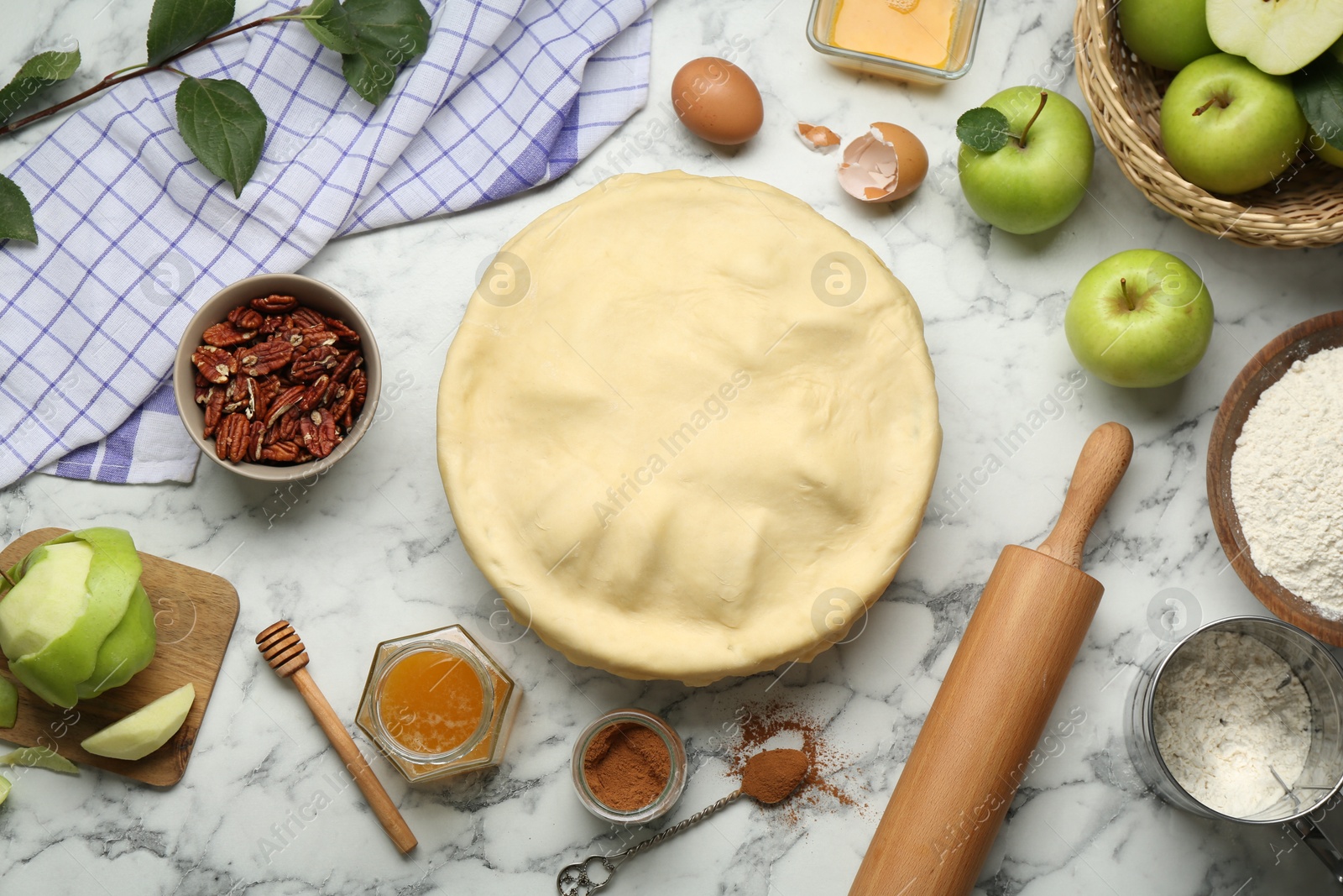 Photo of Flat lay composition with raw homemade apple pie and ingredients on white marble table