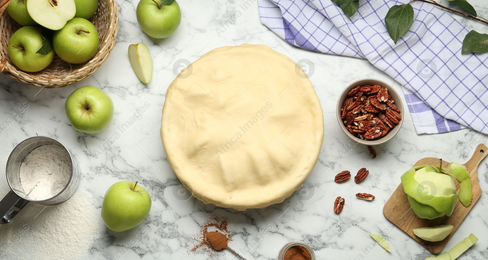 Photo of Flat lay composition with raw homemade apple pie and ingredients on white marble table