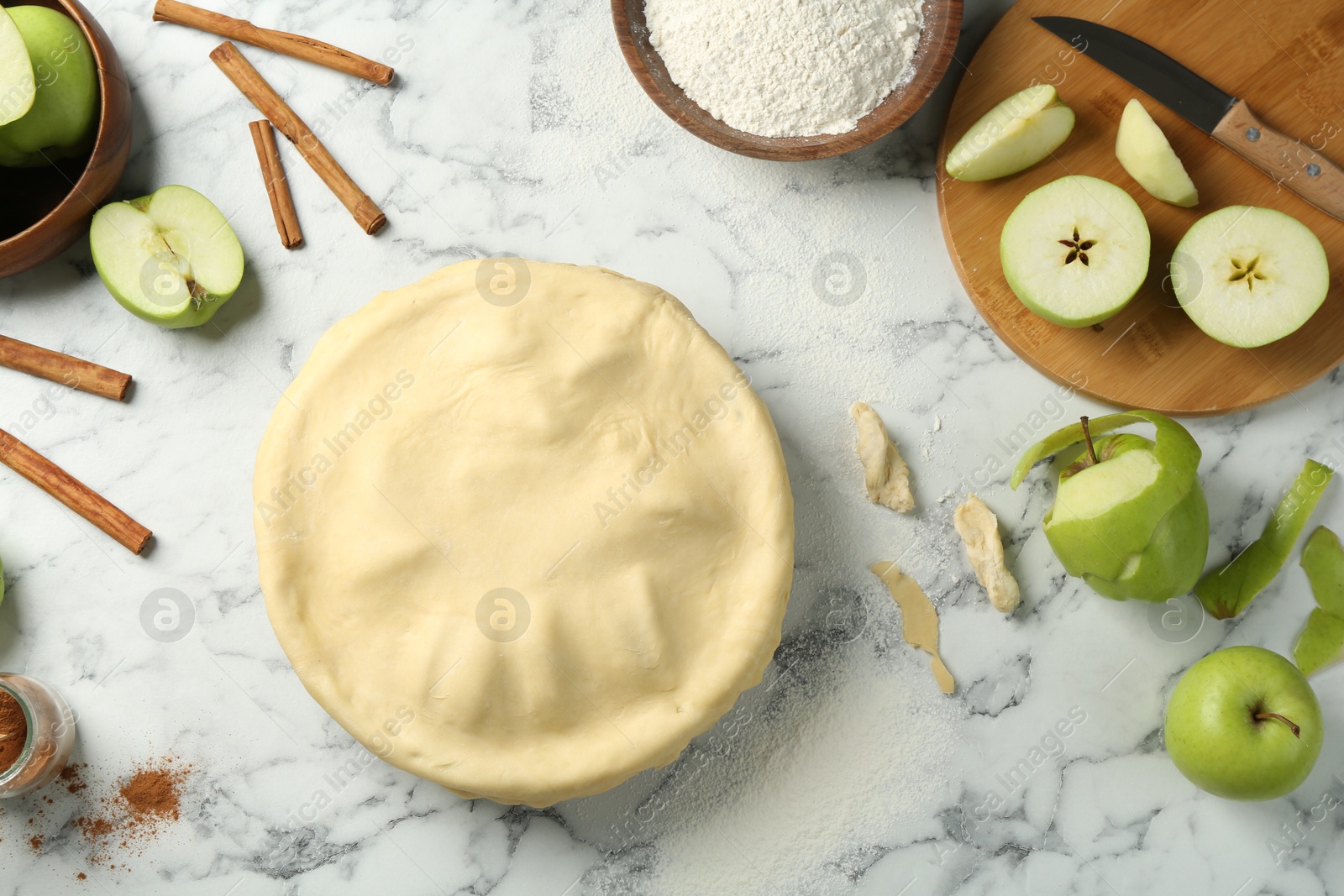 Photo of Flat lay composition with raw homemade apple pie and ingredients on white marble table