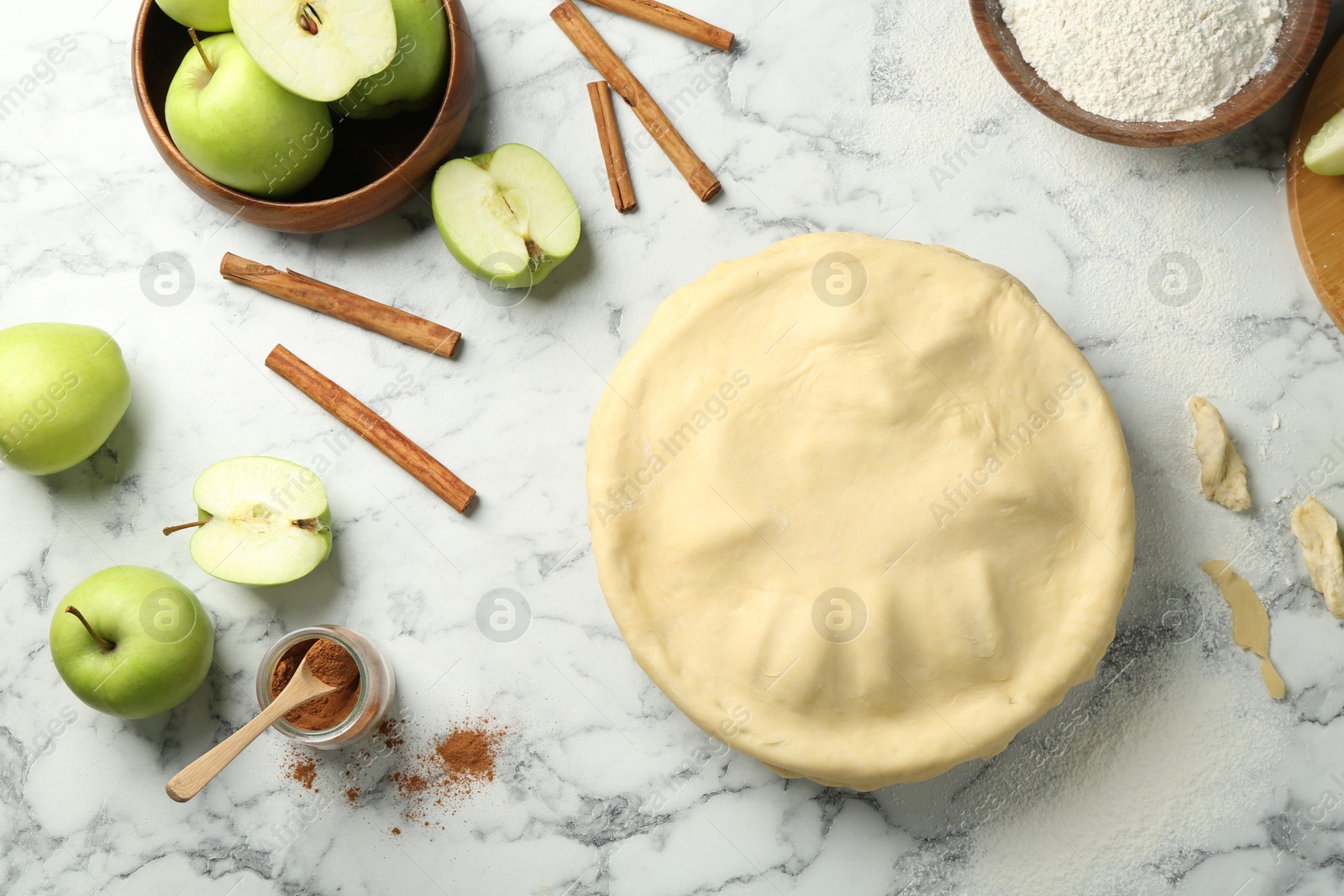 Photo of Flat lay composition with raw homemade apple pie and ingredients on white marble table