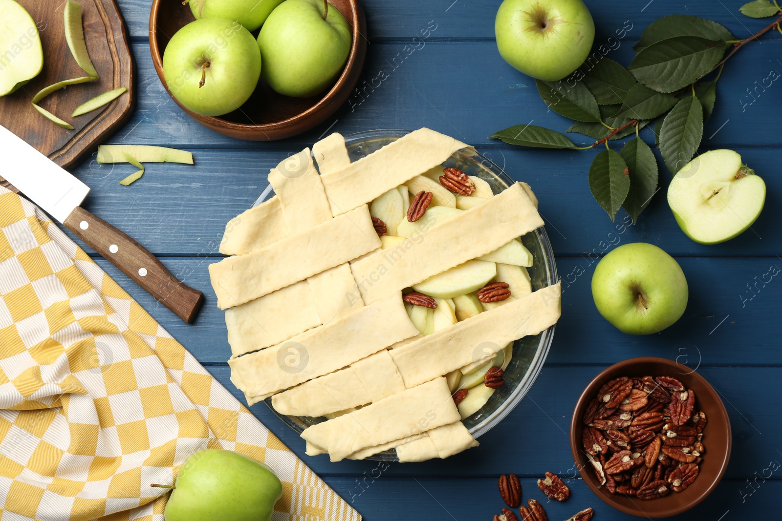 Photo of Flat lay composition with raw homemade apple pie and ingredients on blue wooden table