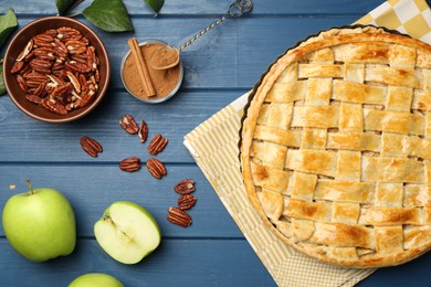 Photo of Flat lay composition with tasty homemade apple pie and ingredients on blue wooden table