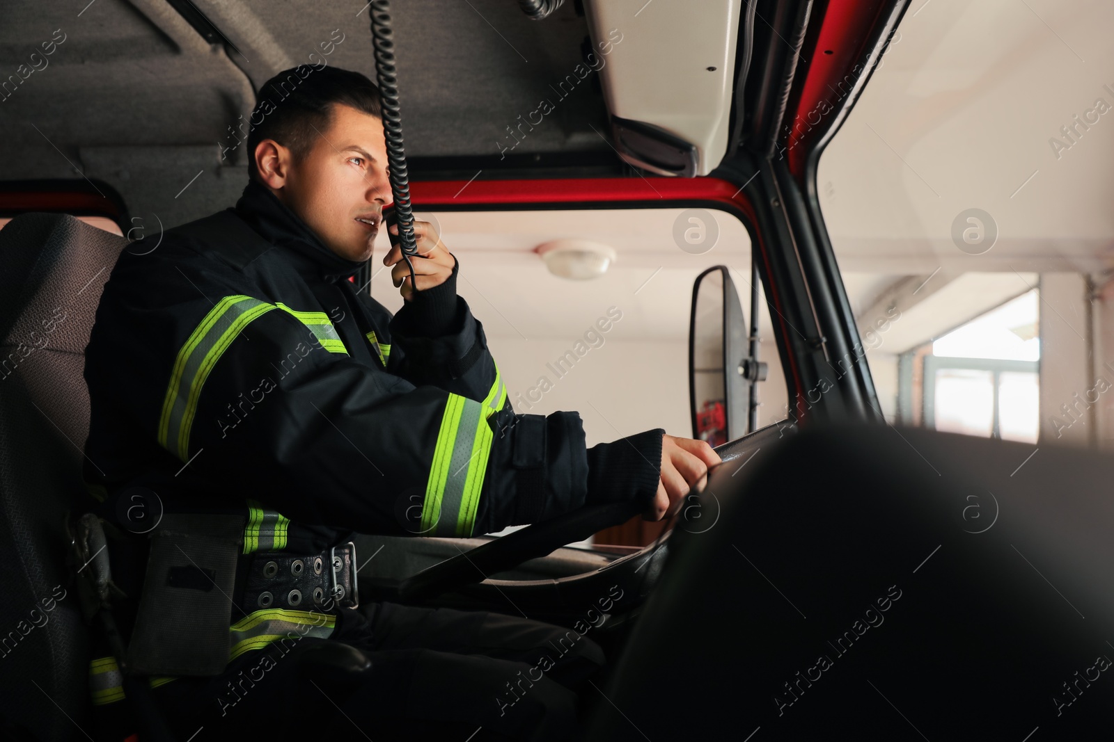 Photo of Firefighter using radio set while driving fire truck