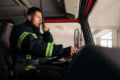 Photo of Firefighter using radio set while driving fire truck