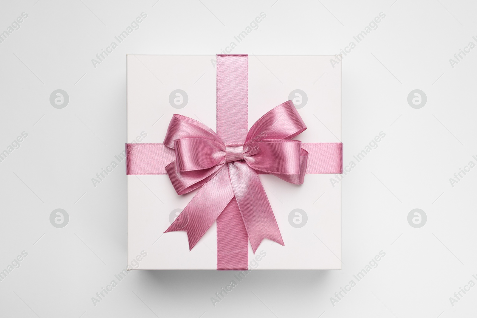 Photo of Gift box with pink bow on light grey background, top view