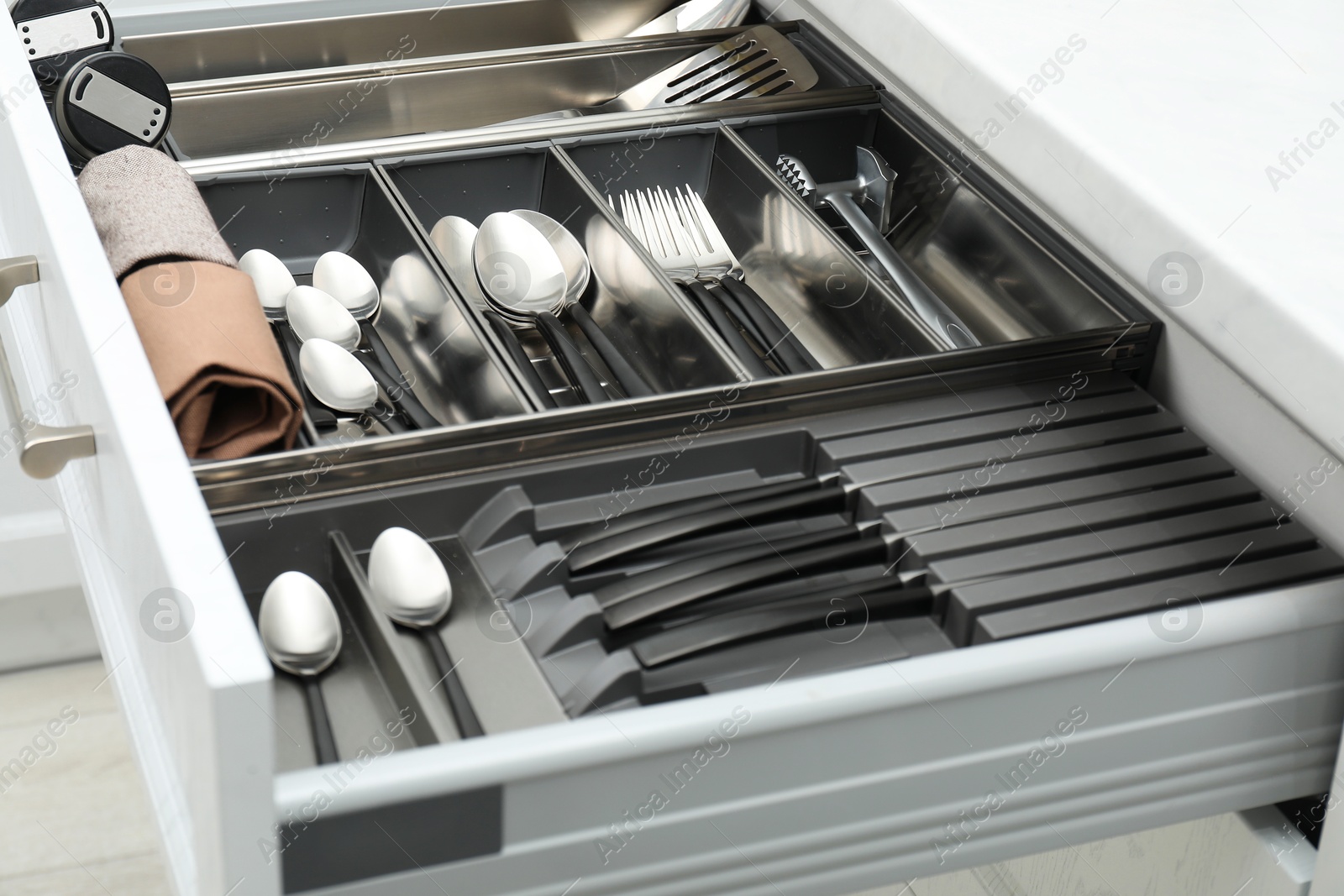 Photo of Box with cutlery in drawer, closeup. Kitchen utensils storage