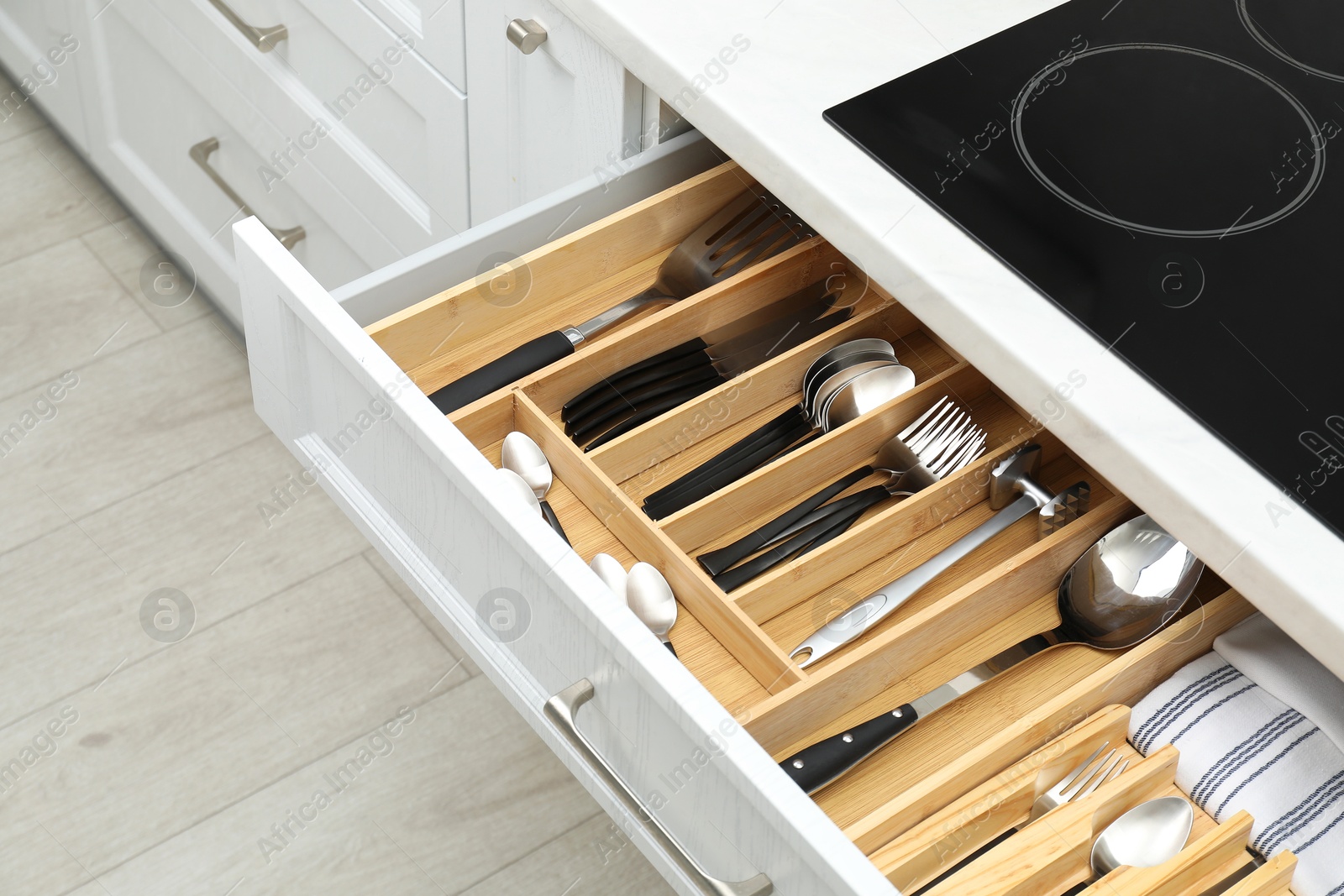 Photo of Box with cutlery in drawer, closeup. Kitchen utensils storage