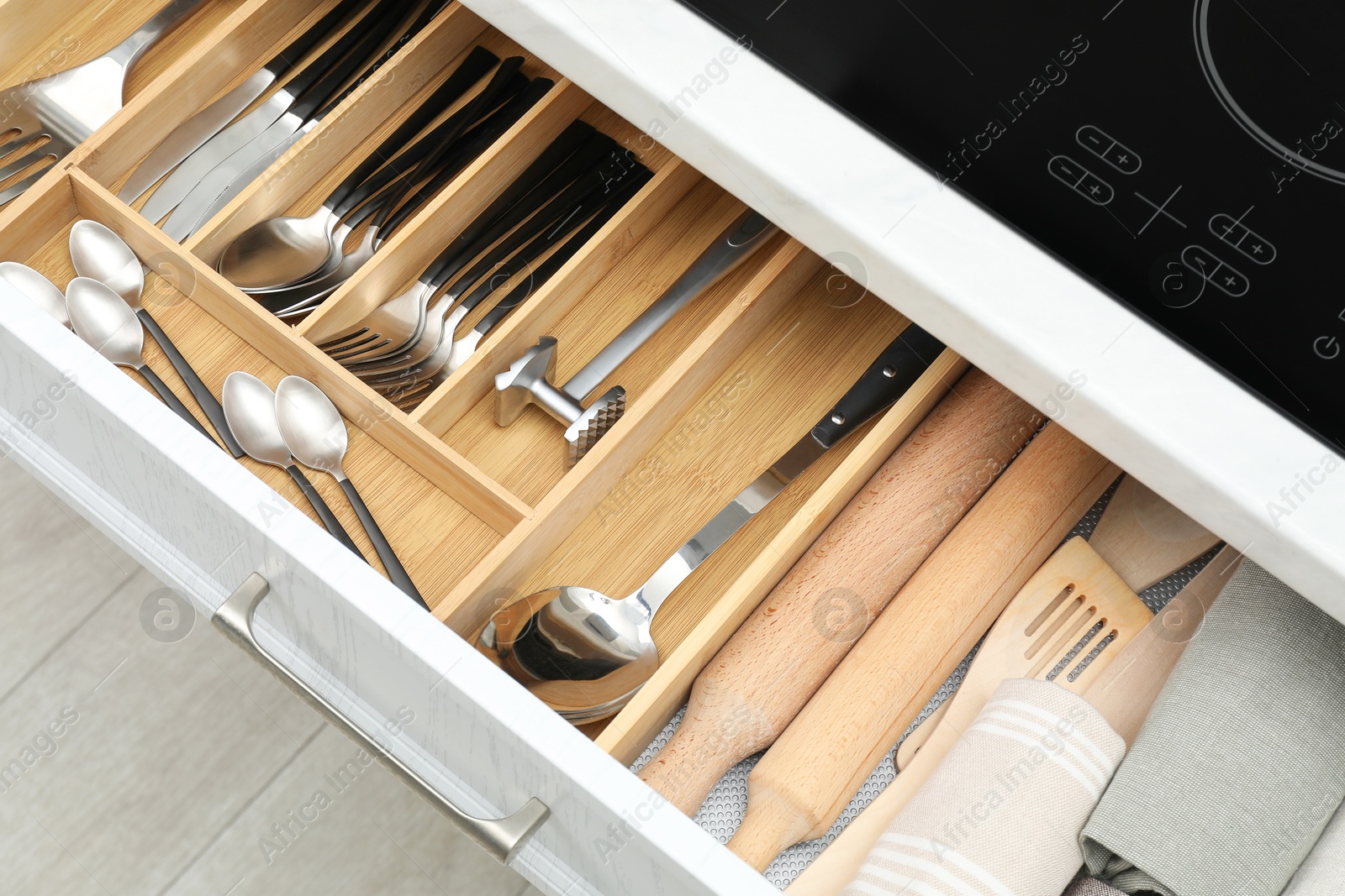 Photo of Box with cutlery in drawer, closeup. Kitchen utensils storage