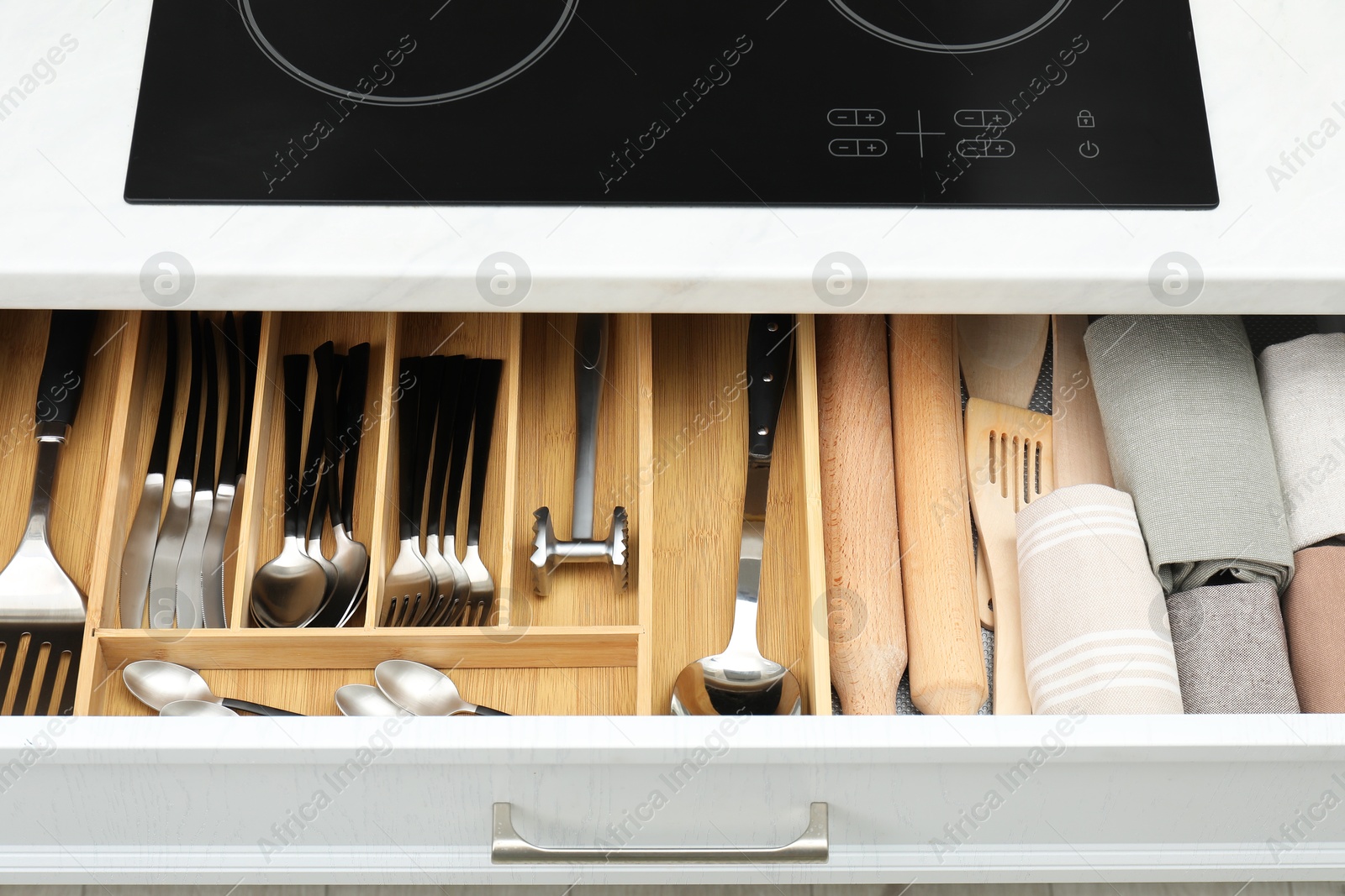 Photo of Box with cutlery in drawer, closeup. Kitchen utensils storage