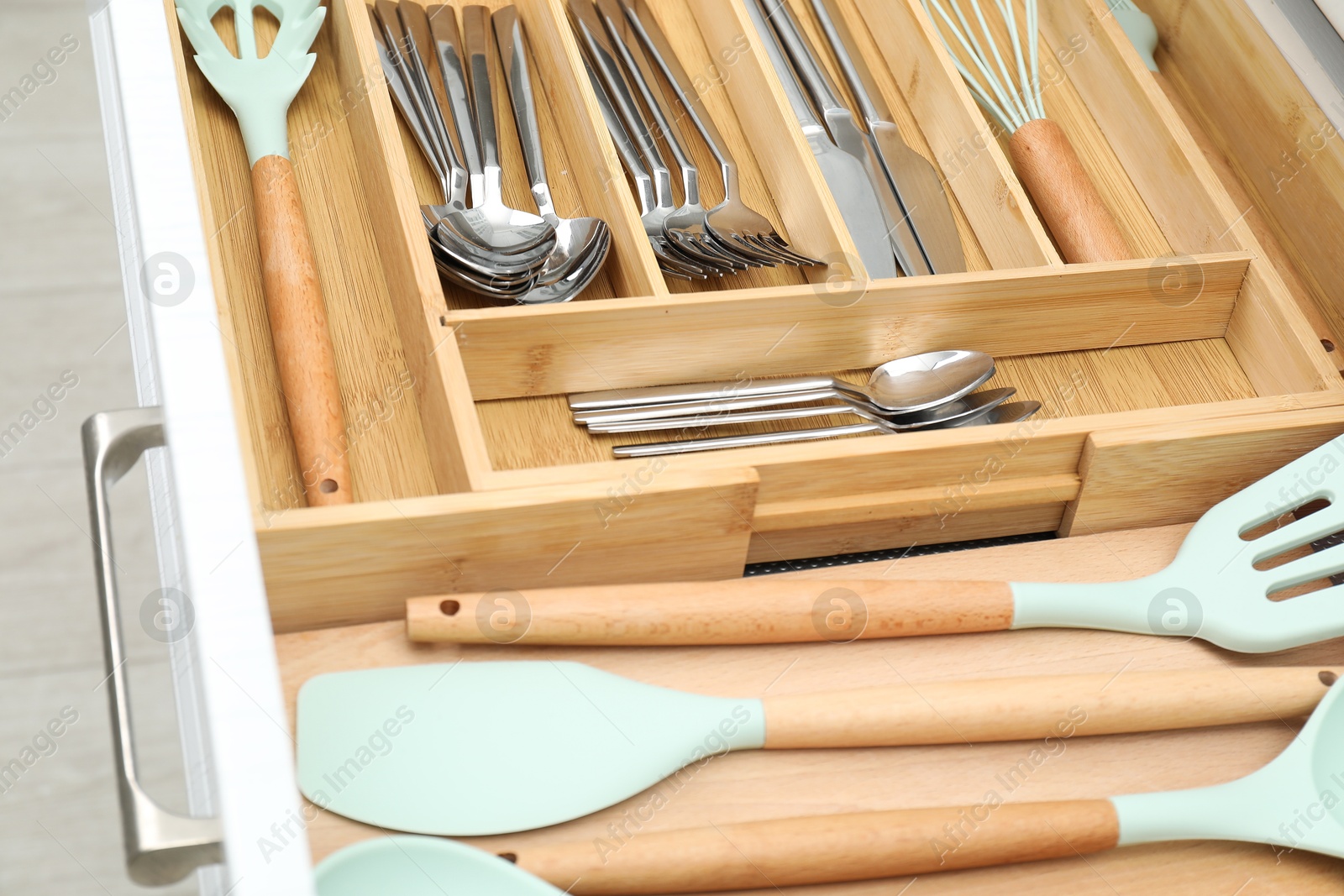 Photo of Box with cutlery in drawer, closeup. Kitchen utensils storage