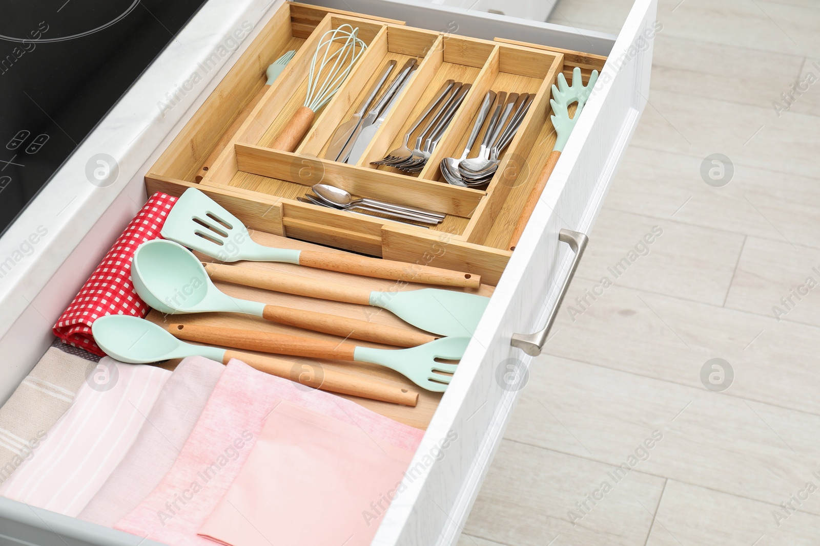 Photo of Box with cutlery in drawer, closeup. Kitchen utensils storage