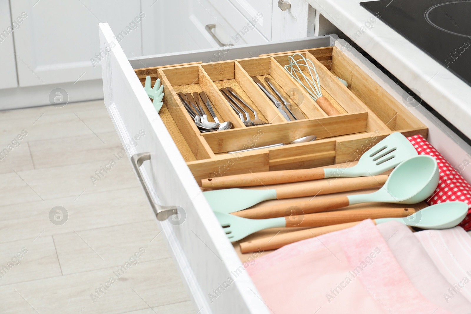 Photo of Box with cutlery in drawer, closeup. Kitchen utensils storage