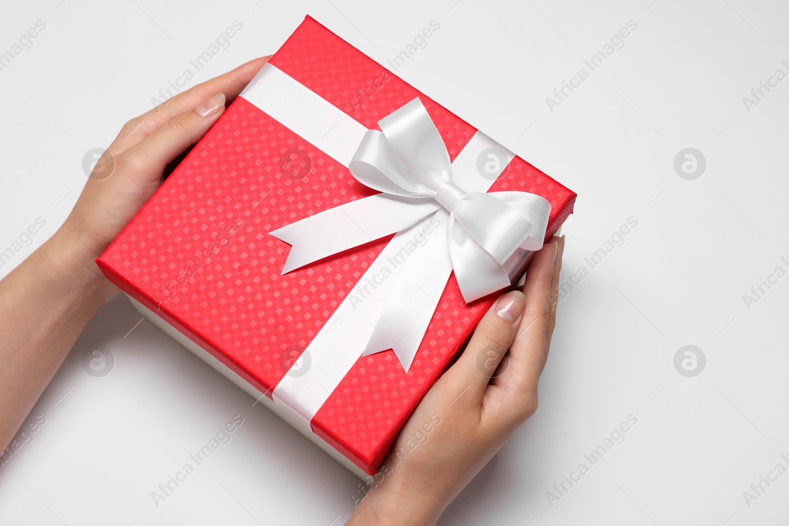 Photo of Woman holding gift box with bow on white background, closeup