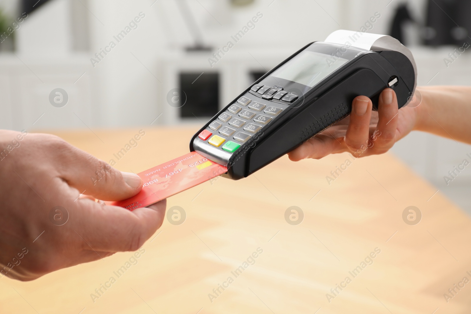 Photo of Customer making payment by putting credit card into POS machine indoors, closeup