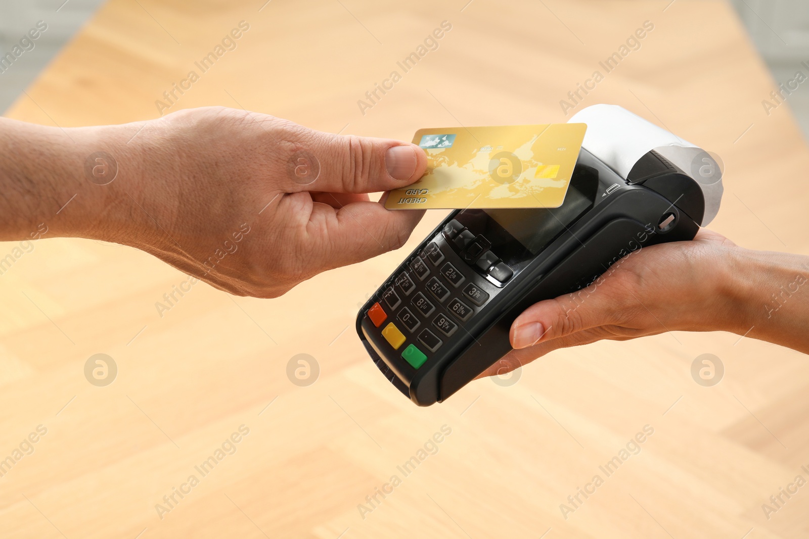 Photo of Customer paying with credit card using POS machine indoors, closeup