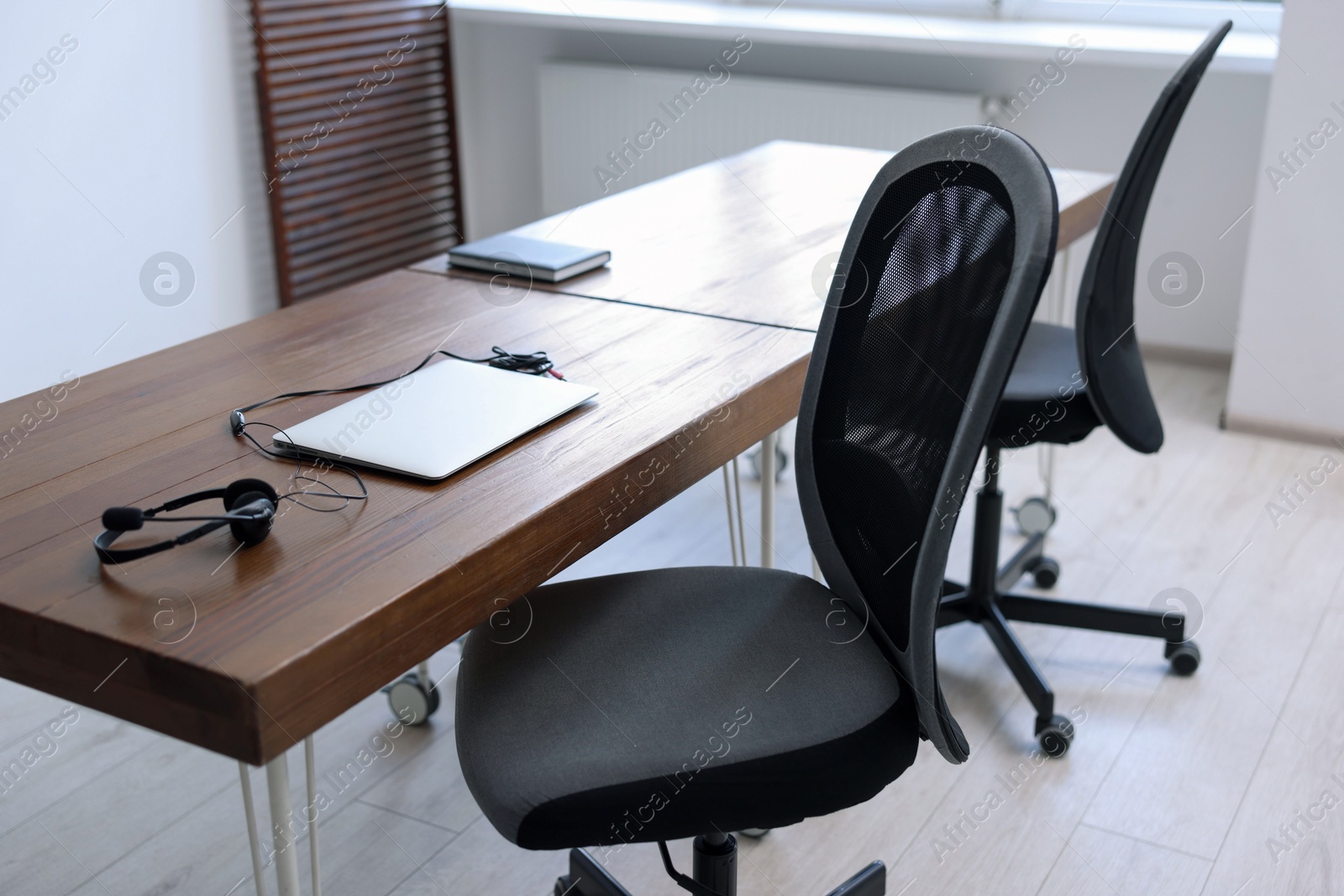 Photo of Black chairs, laptop and desk in office