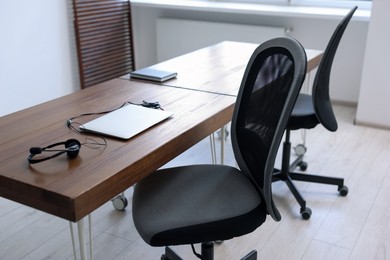 Black chairs, laptop and desk in office