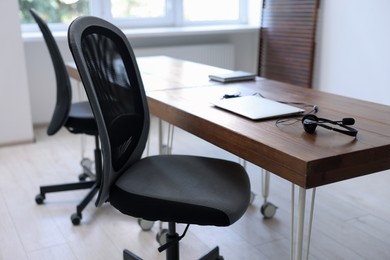 Photo of Black chairs, laptop and desk in office