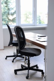 Photo of Black chairs, laptop and desk in office