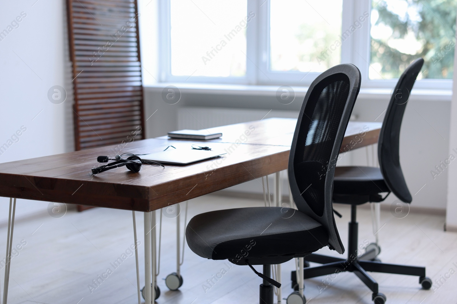 Photo of Black chairs, laptop and desk in office