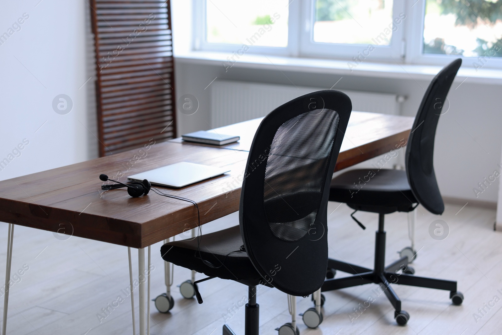 Photo of Black chairs, laptop and desk in office