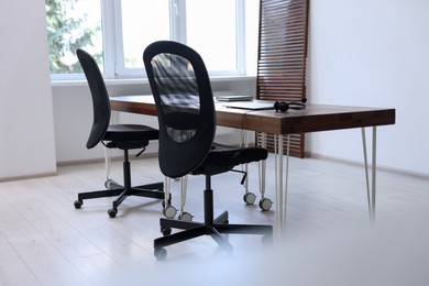 Black chairs, laptop and desk in office