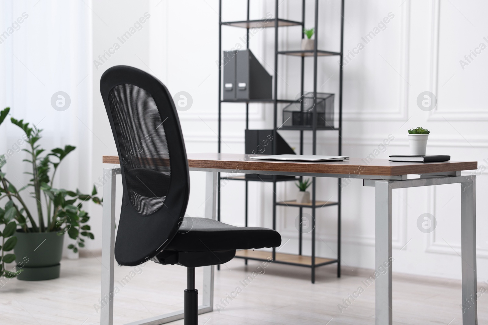 Photo of Black chair, laptop and desk in office