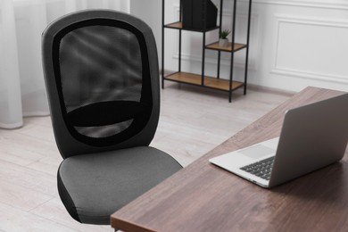 Photo of Black chair, laptop and desk in office