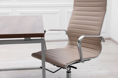 Beige leather chair and desk in office