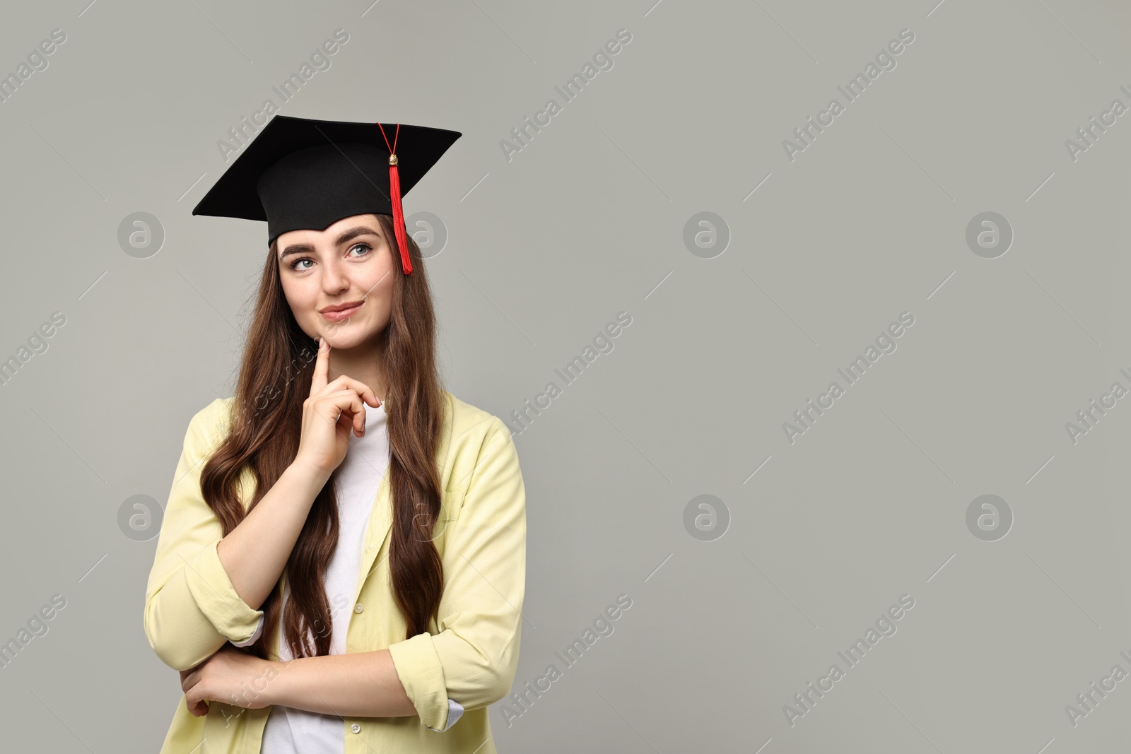 Photo of Thoughtful student after graduation on grey background. Space for text