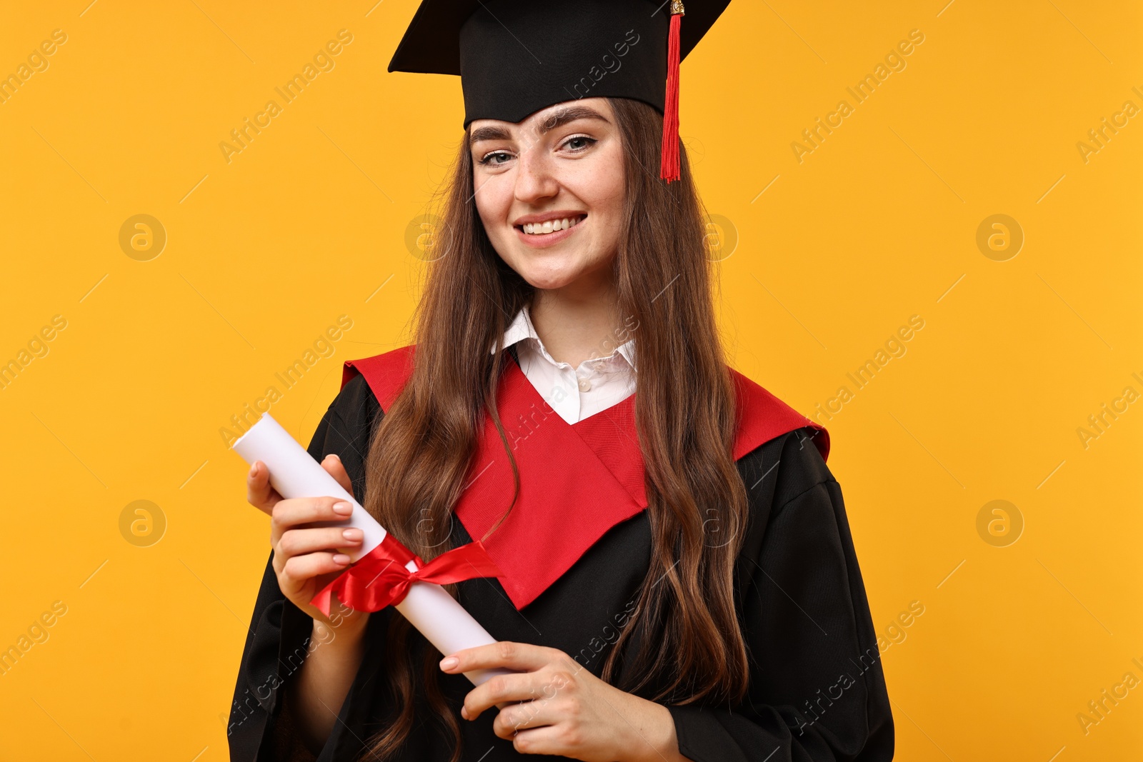 Photo of Happy student with diploma after graduation on orange background