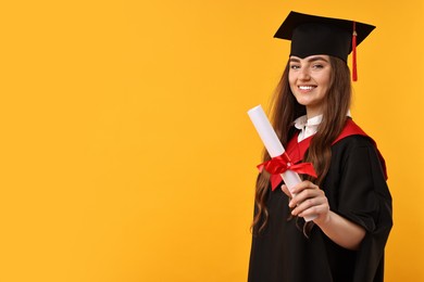 Happy student with diploma after graduation on orange background. Space for text